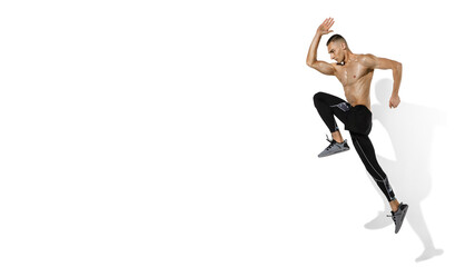 Fototapeta na wymiar Running, jumping. Stylish young male athlete on white studio background, portrait with shadows. Sportive fit model in motion and action. Body building, healthy lifestyle, style concept. Flyer