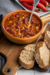 Chili con carne. Mexican food with beans in pot and bread