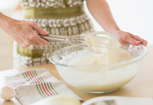 Midsection of woman whisking batter