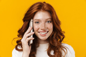 Image of ginger happy girl smiling and talking on mobile phone