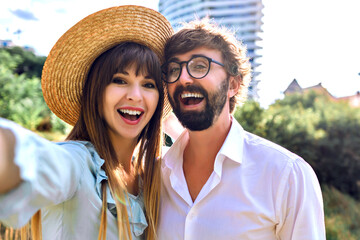 Obraz premium Pretty positive couple wearing vintage elegant outfits, making selfie and smiling