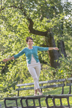 Mature Woman Walking On Bench