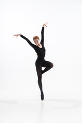Naklejka na ściany i meble Black bird. Young and graceful ballet dancer in minimal black style isolated on white studio background. Art, motion, action, flexibility, inspiration concept. Flexible caucasian ballet dancer.