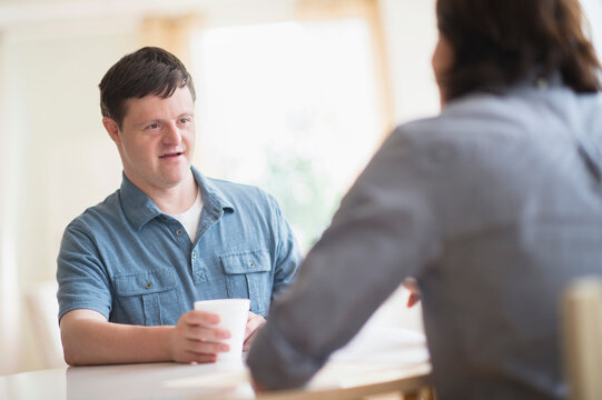 Man with down syndrome talking with care taker