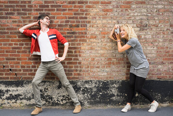 Woman taking pictures of man