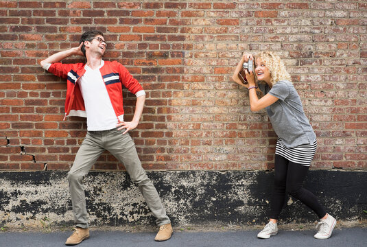 Woman taking pictures of man