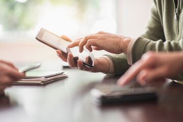 Close up of hands of men and woman working with electronical devices