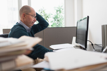 Surprised mature businessman looking at computer monitor