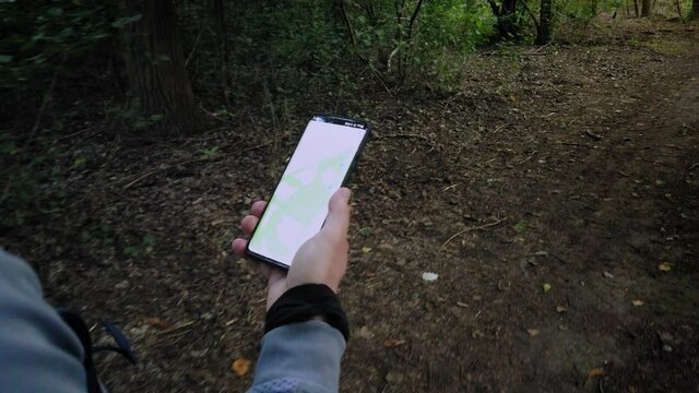 Walking in the forest, hiking trail, smart android navigation app in hand -  4k footage