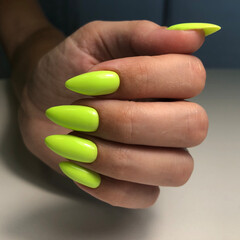 Stylish trendy green female manicure.Hands of a woman with green manicure on nails