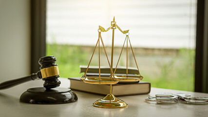 Justice scales and books and wooden hammer lawyer with handcuffs on the table Concept of justice