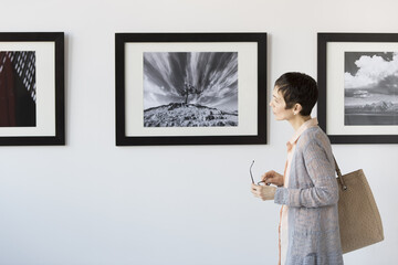 Woman watching photographs in art gallery