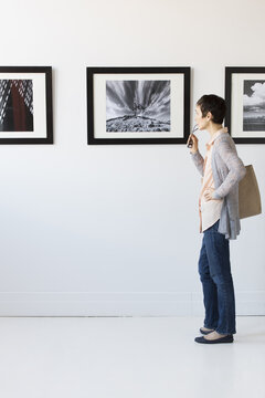 Woman watching photographs in art gallery