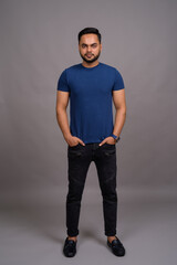 Fototapeta premium Young bearded Indian man against gray background