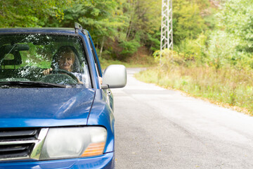 Senior lady drives the car in outdoor