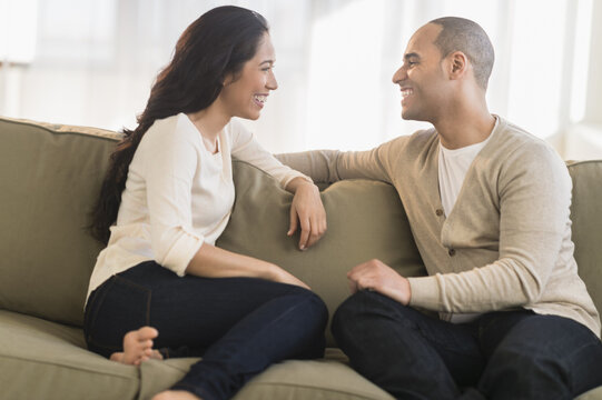 Portrait Of Young Couple Sitting On Couch