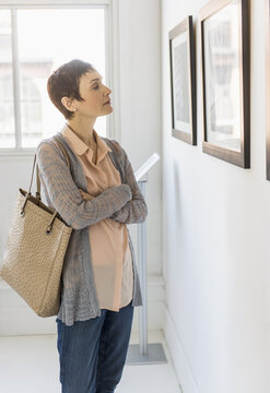 Woman watching photographs in art gallery