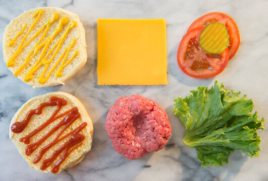 Close-up shot of hamburger ingredients in rows on table