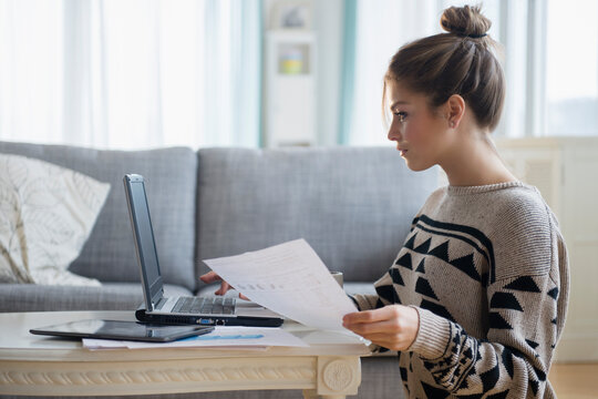 Young woman working with laptop in living room