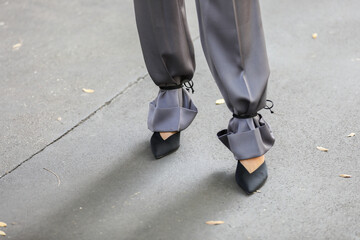 Fototapeta premium September 24, 2020: model wears a pair of black heeled shoes and a pair of gray pants