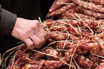 Chinese cantonese sausage, chinese characteristic food made from pork , man picking up the...