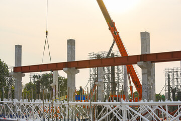 Construction workers installation steel structure girder runway beam lifting by mobile crane and placing on corbel of column concrete at the construction site project © Sumith Nunkham