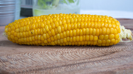 Delicious corn on the cob captured in an extreme close up. The brightly glowing yellow kernels form a recognizable pattern. The cob was lightly boiled and seasoned with salt.
