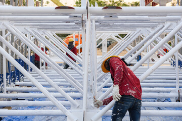 Workers are fireproof painting steel structure roof truss before lifting to installation at the...