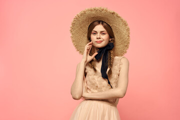 Fashionable woman in dress and hat with black ribbon on pink background cropped view of model emotions fun