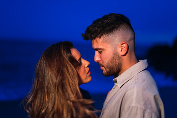 Pareja en al playa en al hora azul juntos y riendo