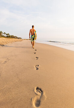 Rear view of surfer on beach