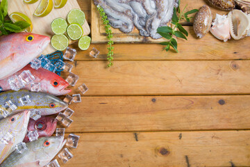 Seafood, composition with fresh tropical fishes, lobster, seashells and octopus on wooden table. Ingredients from Venezuela in South America.