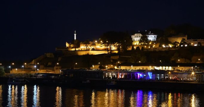 Night Downtown Timelapse of Belgrade old Citadel and Fortress Kalemegdan with Light Reflections on the Sava River Water. The Victory Monument Pobednik, Symbol of Belgrade, is visible on the Terrace. 