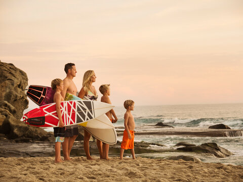 Family with three children (6-7, 10-11, 14-15) looking at sea