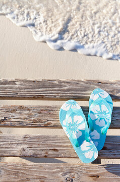 Flip flops on pier by sea