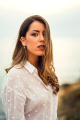 Chica con blusa blanca y bonita sonrisa en un acantilado