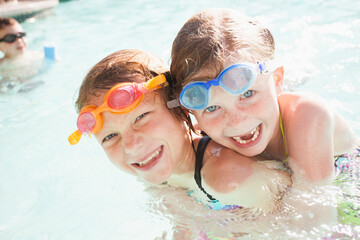 Girlfriends (4-5, 8-9) playing in swimming pool