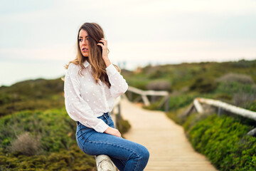 Chica con blusa blanca y bonita sonrisa en un acantilado