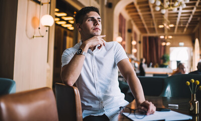 Handsome pensive man in cafe thinking and looking away