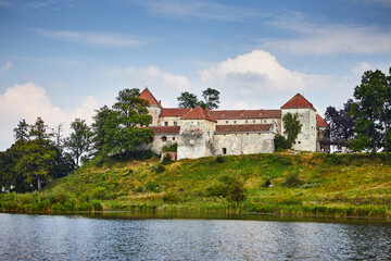 Ancient Svirzh castle with lake and trees in Lviv region