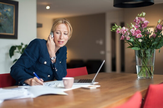 Woman talking on phone and making notes