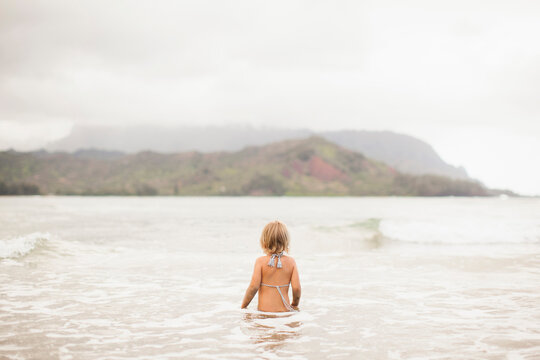 Baby girl (2-3) wading in ocean
