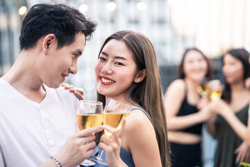 Group of Asian young people hold wine glass and clink glasses in party