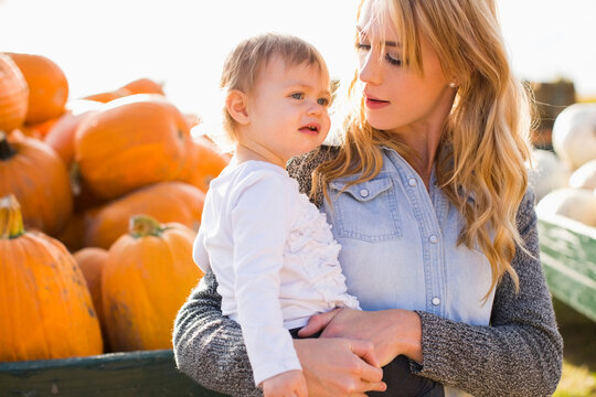 Mother and daughter (12-17 months) with pumpkins in background