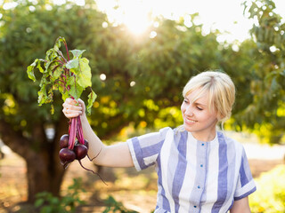 Woman wearing striped dress working in vegetable garden