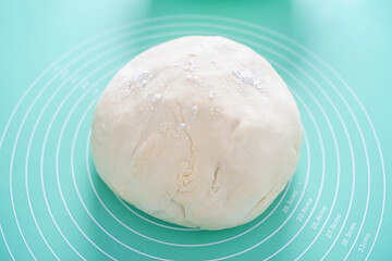A lump of dough on a silicone kneading mat