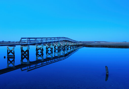 Bridge reflecting in water, blue image