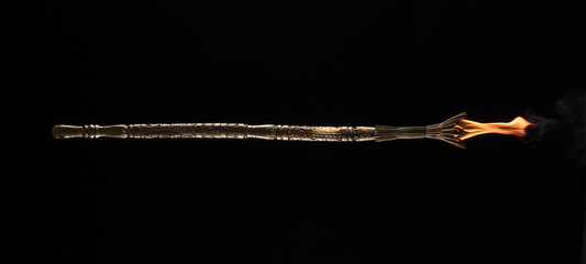 Fototapeta premium fire magic staff on a black background