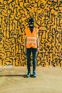 Young graffiti writer in front of his work
