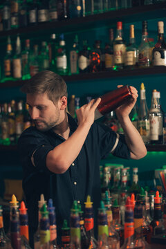 Barkeeper with shaker shaking cocktail